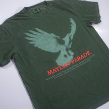 Load image into Gallery viewer, A green Mayday Parade Comfort Colors T-Shirt features a faded flying bird graphic, bold red puff print "MAYDAY PARADE," and small white text below.