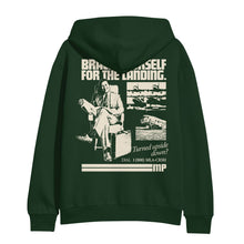 Load image into Gallery viewer, image of the back of a forest green pullover hoodie on a white background. hoodie has an image of a man sitting with a suitcase and a collage of airplanes. across the shoulders says brace yourself for the landing. on the bottom right says Turned upside down? dial 1 800 m l s c r s h
