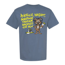 Load image into Gallery viewer, A blue, garment-dyed Mayday Parade T-shirt featuring a cartoon wild, disgruntled creature with a yellow paintbrush, spilled coffee mug, and the text Another night, another dream wasted on you in bold yellow and white letters.