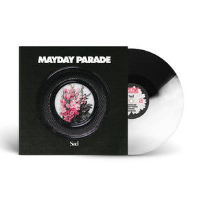 A black and white Mayday Parade vinyl (Black And Clear Blend Variant) is partly out of its sleeve. The cover displays MAYDAY PARADE above a round window with pink flowers in a vase and Sad at the bottom.