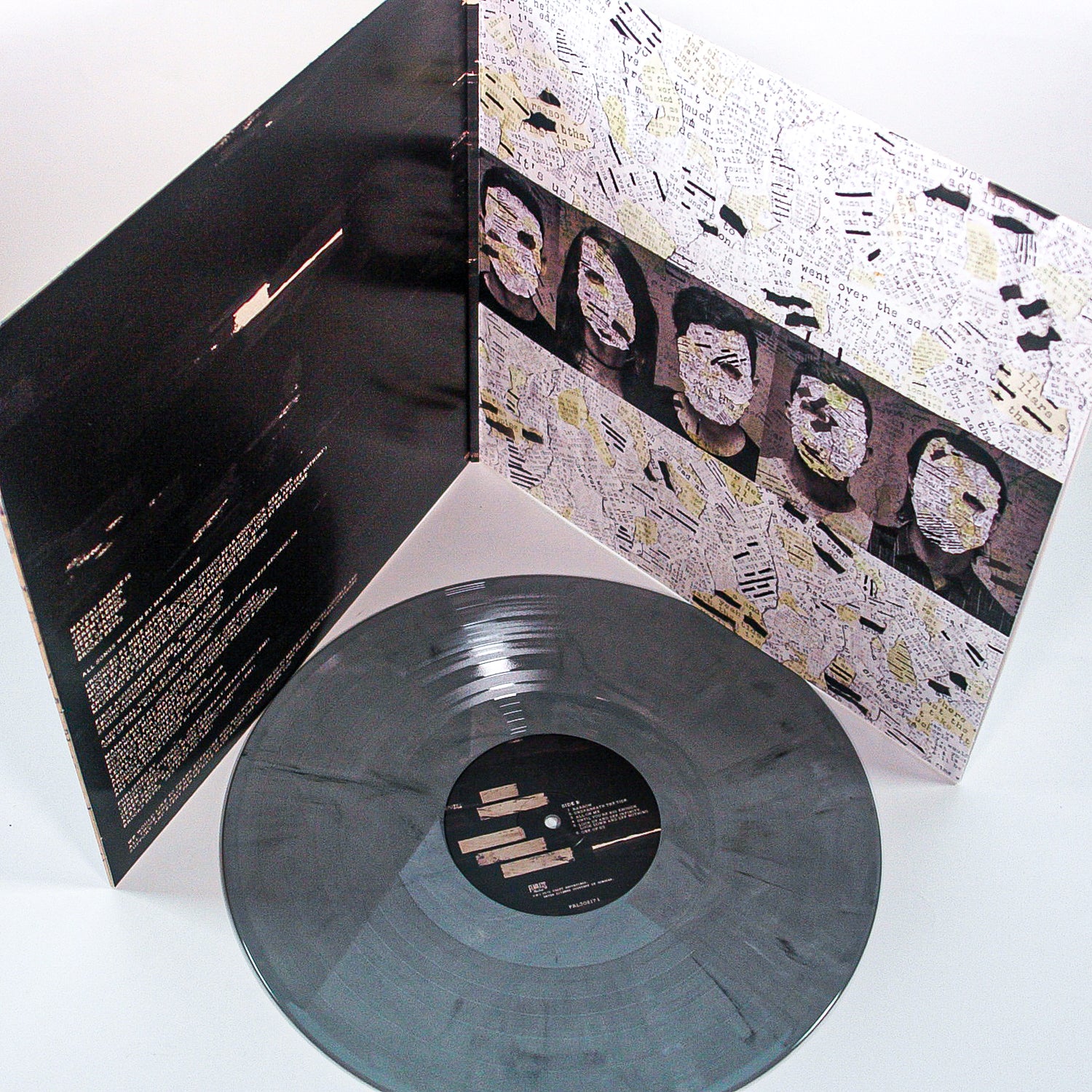 A marbled gray and black Graphite Vinyl LP by Mayday Parade is in front of an open album cover with collage art featuring faces and text clippings. The inner sleeve displays song lyrics in white on a black background.