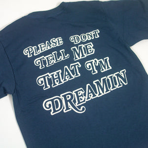 image of a blue tee on a white background. white print that says:   please don't tell me that I'm dreamin'