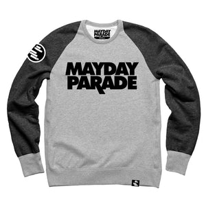 image of crewneck sweatshirt on a white background. the sleeves are a dark heather grey, and the chest/body is light heather grey. back neck tag and front chest of crewneck says stacked in black mayday parade. circle black patch with white rectangles is on the left sleeve and a small tag at the bottom right.