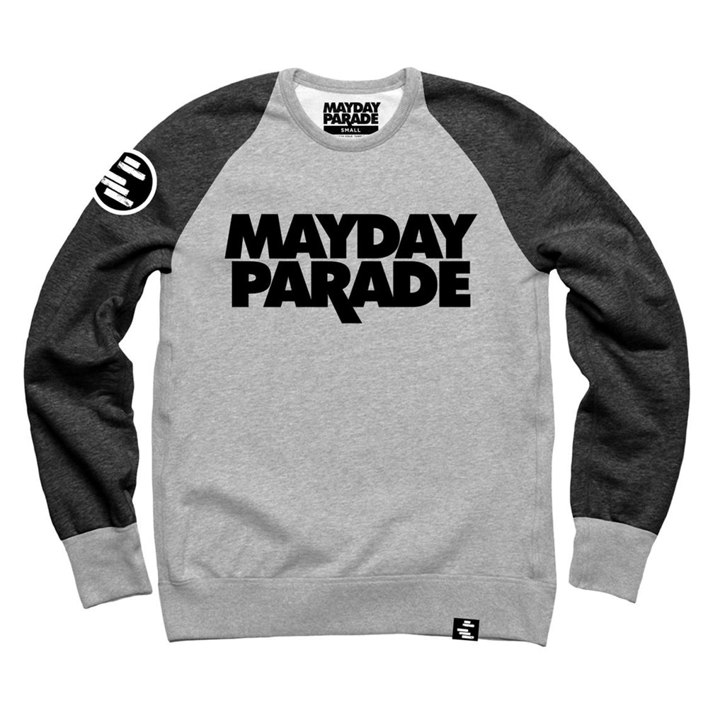 image of crewneck sweatshirt on a white background. the sleeves are a dark heather grey, and the chest/body is light heather grey. back neck tag and front chest of crewneck says stacked in black mayday parade. circle black patch with white rectangles is on the left sleeve and a small tag at the bottom right.