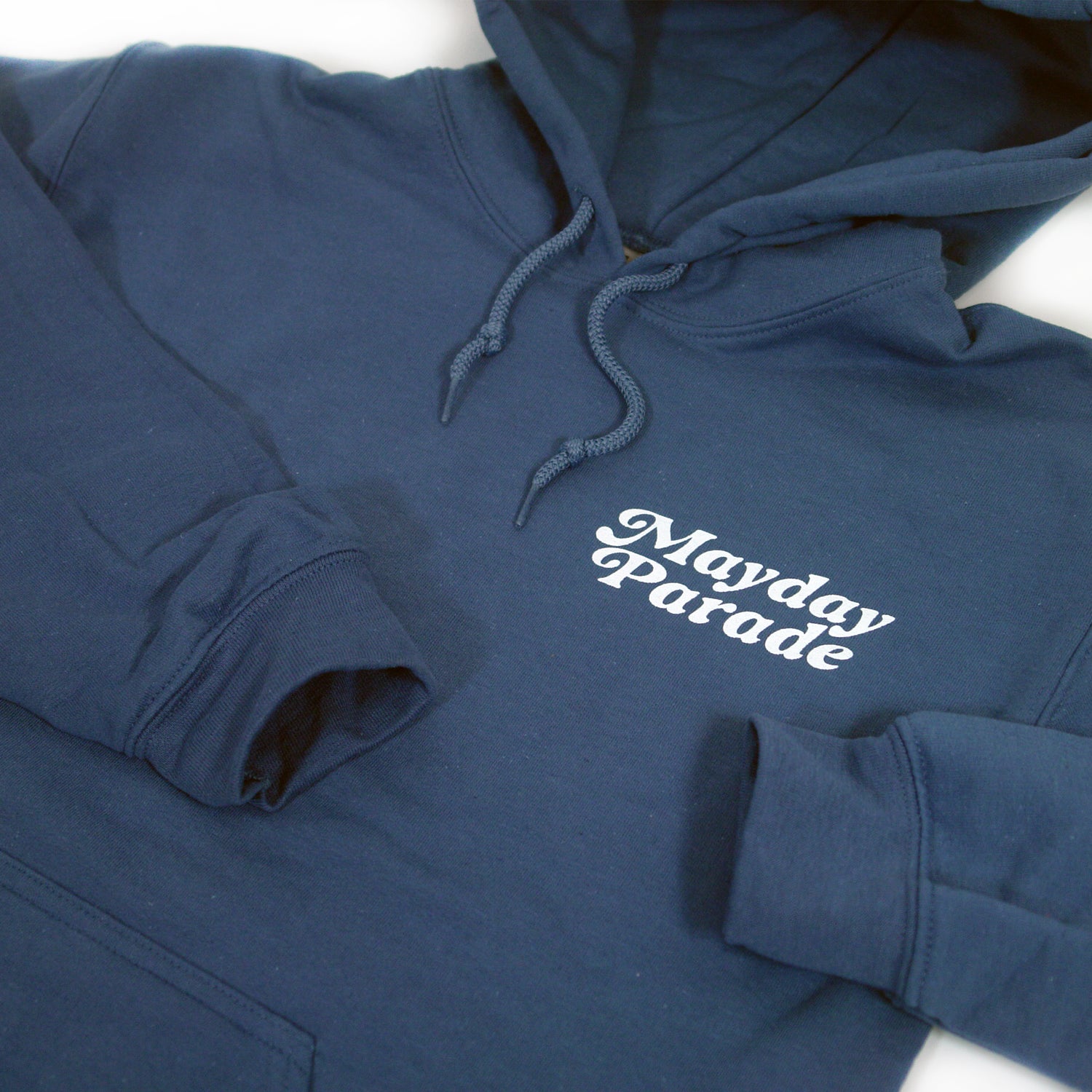close up, angled image of the front of an indigo colored pullover hoodie on a white background. the hoodie has a small right chest print that says mayday parade.