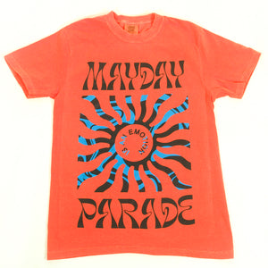 image of the front of a salmon colored tee shirt on a white background. tee has a full body print. at the top says mayday and the bottom says parade. in the center is a blue sun shape and inside says is an emotion.