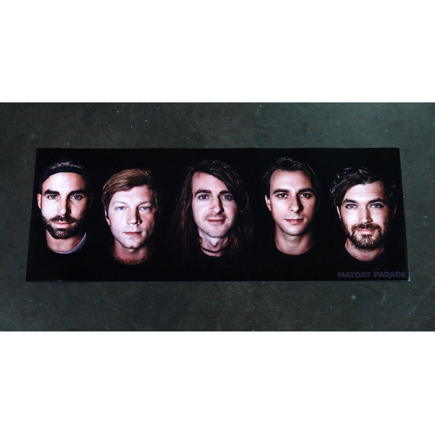 rectangle poster on a concrete background with 5 mens faces and mayday parade at the bottom right