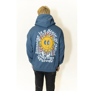 image of a man wearing an indigo pullover hoodie. image of the back of an indigo colored pullover hoodie on a white background. the back of the hoodie has a full back print of a sun with a face, with legs and the arms in the air. arched around the sun says sunshine is a state of mind and across the bottom says mayday parade